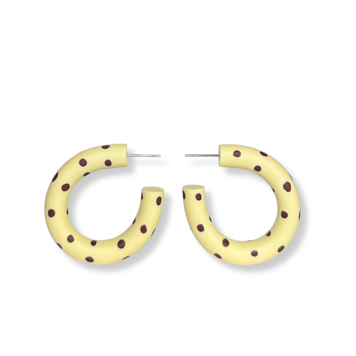 Yellow hoop earrings with brown polka dots on a white background