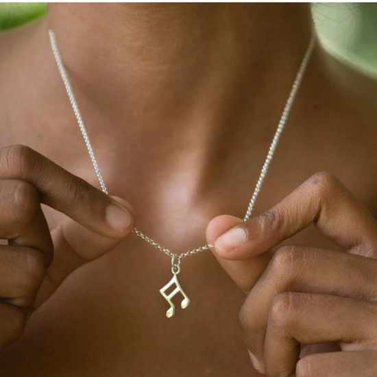 Load image into Gallery viewer, hands holding silver semi quaver charm necklace.

