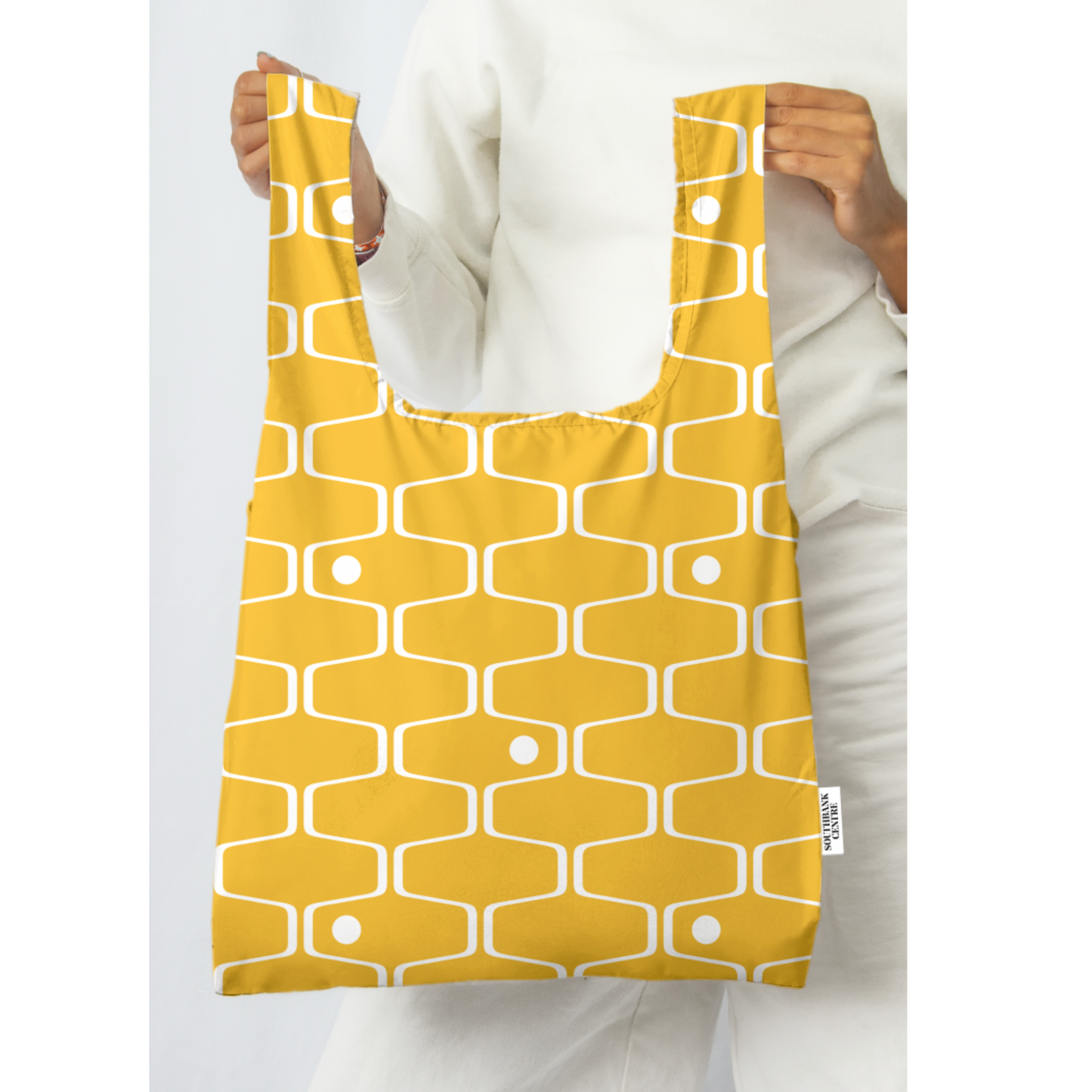 A person holding a kind bag in yellow