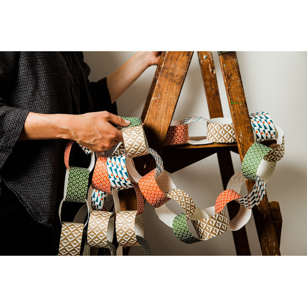 woman on ladder with multi colour paper garland
